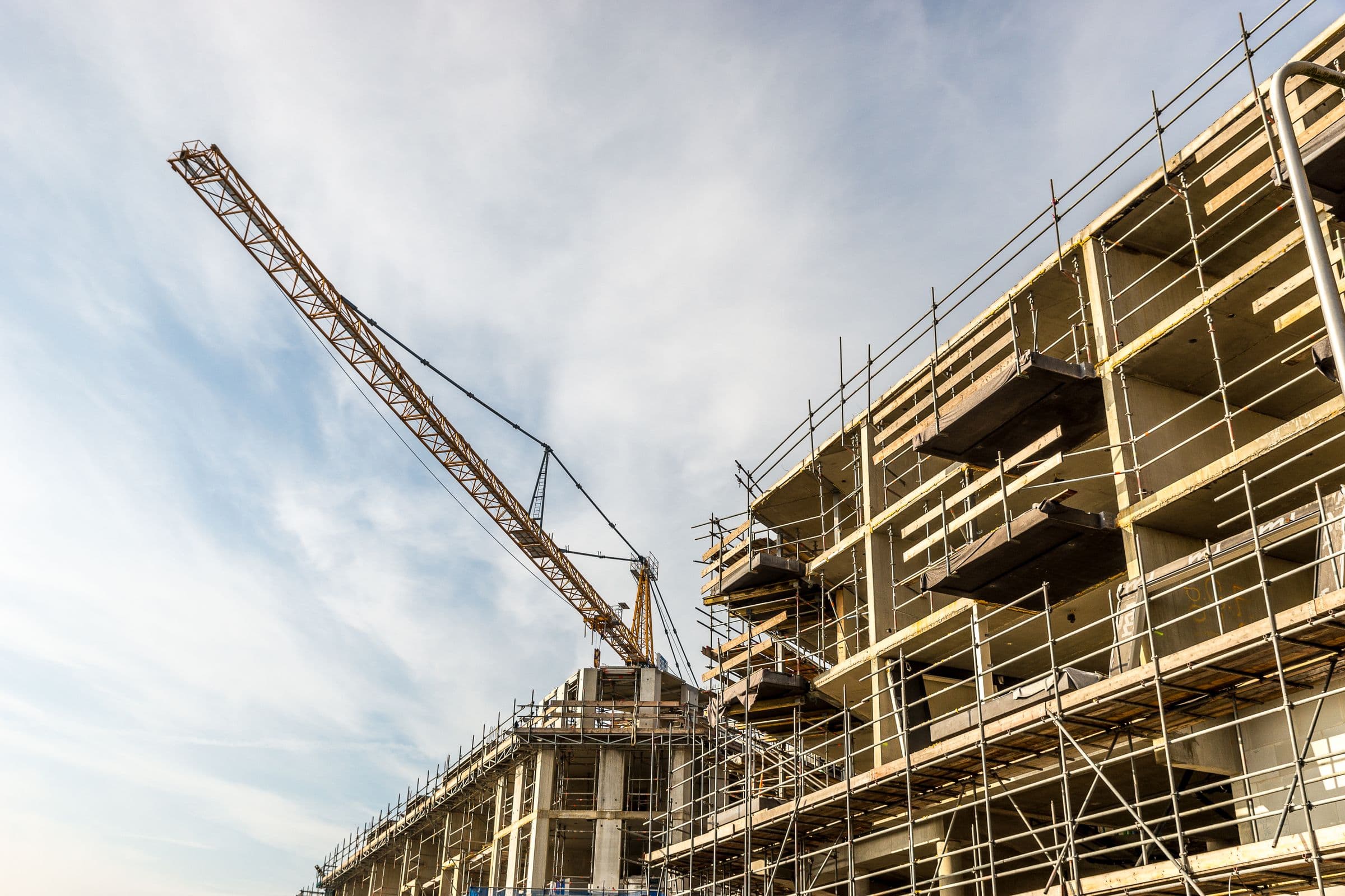 Edifício em construção com guindaste e andaimes