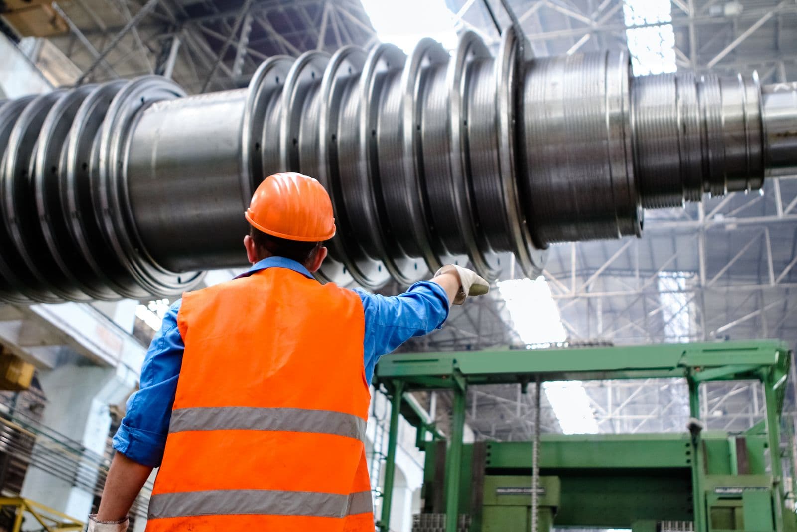 Operário em fábrica junto a equipamento industrial