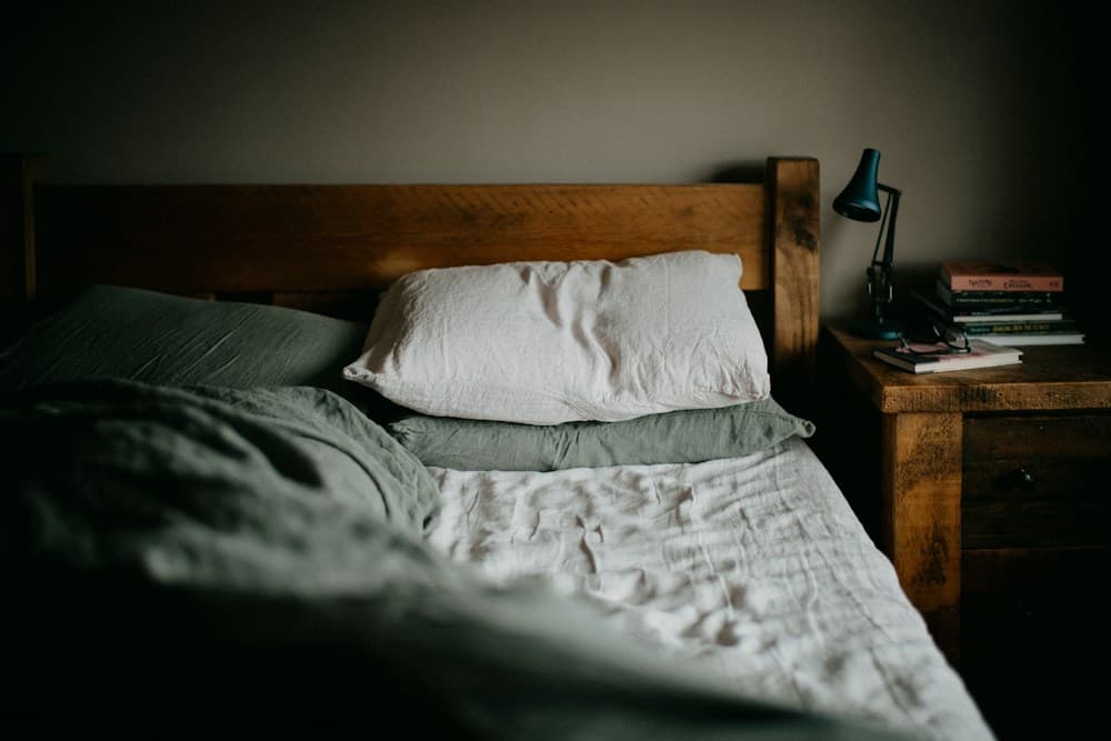Cama com cabeceira de madeira e roupa de cama de linho